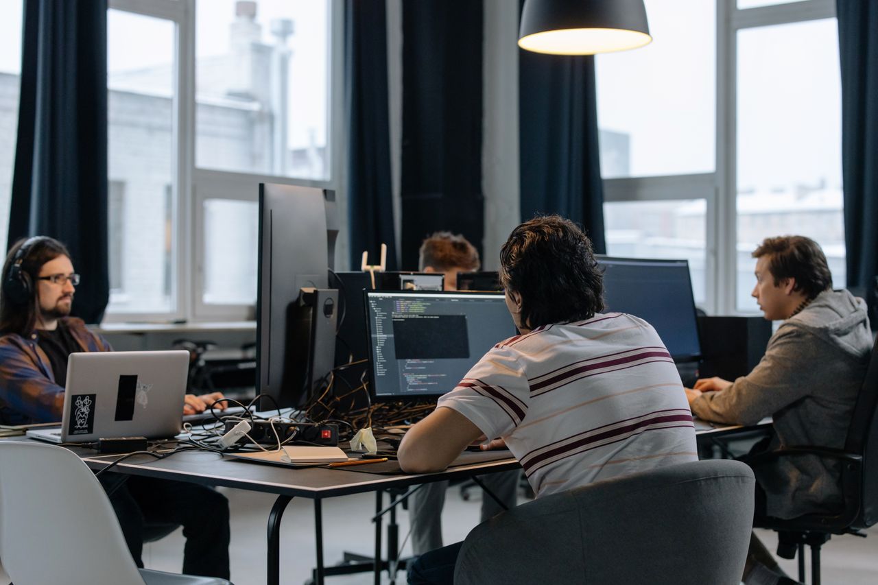 About Team of developers working together on computers in a modern tech office.